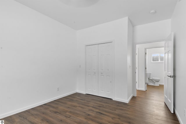 unfurnished bedroom with dark hardwood / wood-style flooring and a closet