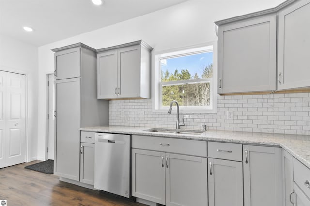 kitchen featuring gray cabinetry, dishwasher, sink, dark wood-type flooring, and backsplash