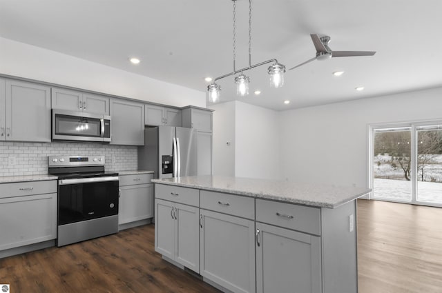 kitchen featuring gray cabinetry, dark wood-type flooring, ceiling fan, appliances with stainless steel finishes, and a kitchen island