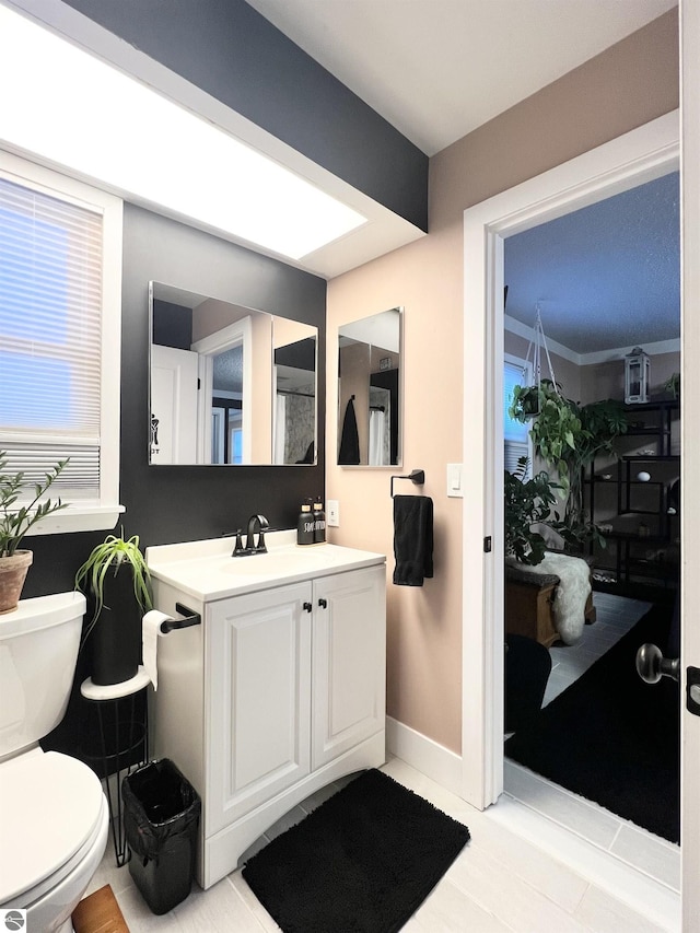 bathroom with vanity, ornamental molding, and toilet