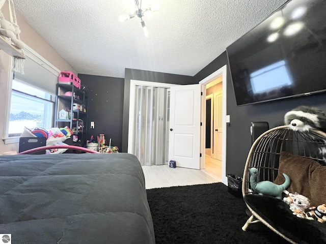 bedroom featuring a textured ceiling and light hardwood / wood-style flooring