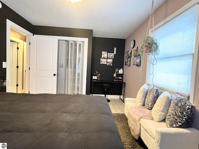 bedroom featuring tile patterned floors, a textured ceiling, and multiple windows