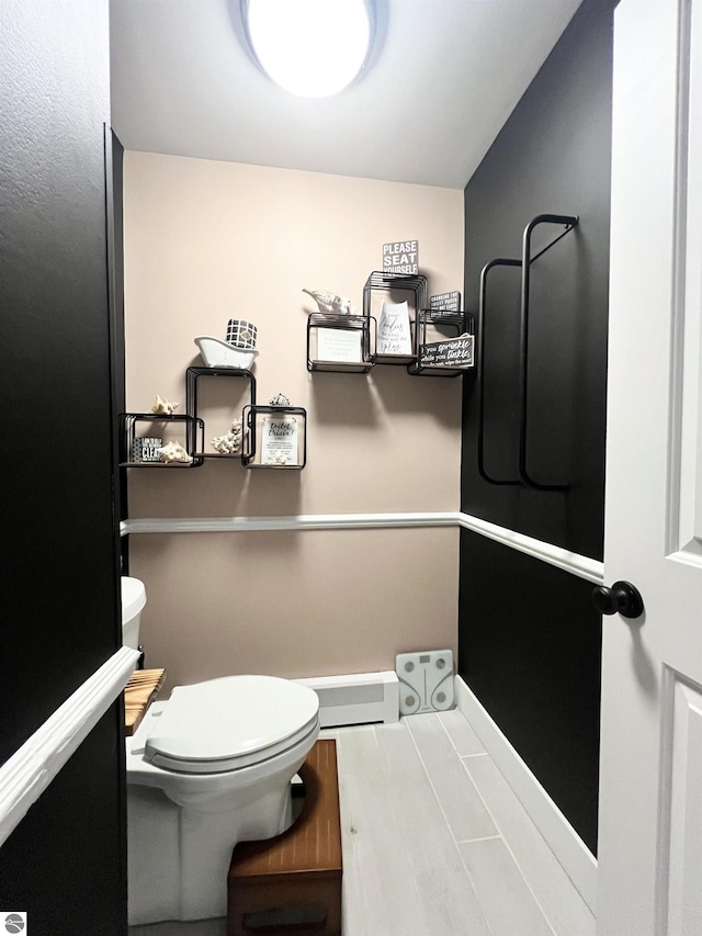 bathroom featuring toilet and a baseboard heating unit