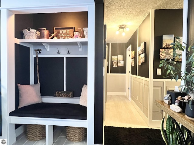 mudroom featuring wood-type flooring and a textured ceiling