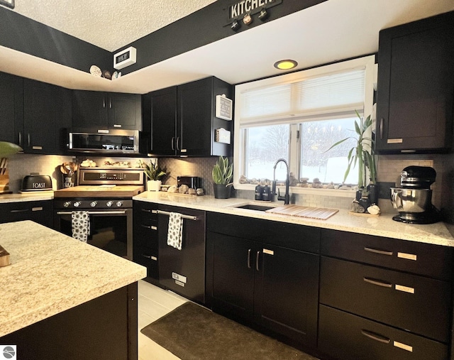 kitchen featuring sink, stainless steel appliances, backsplash, a textured ceiling, and light tile patterned floors