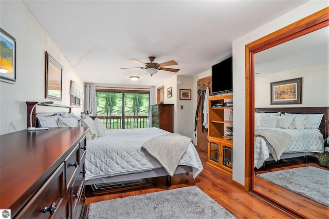 bedroom featuring hardwood / wood-style floors, ceiling fan, and access to exterior