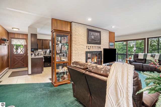 carpeted living room with wood walls, a baseboard radiator, and a brick fireplace