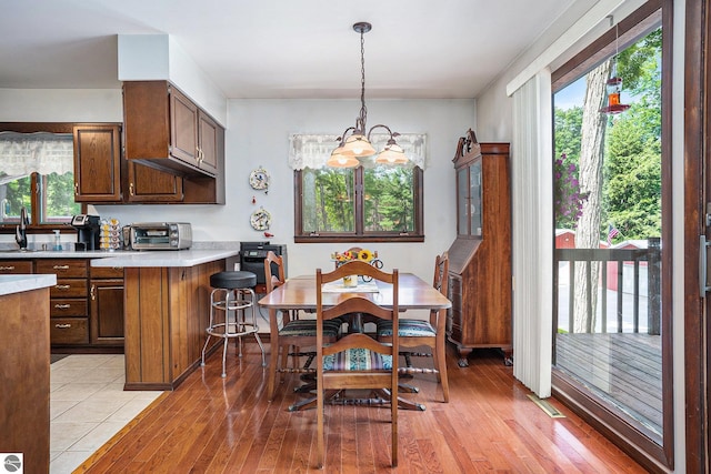 dining space featuring light hardwood / wood-style floors and a chandelier