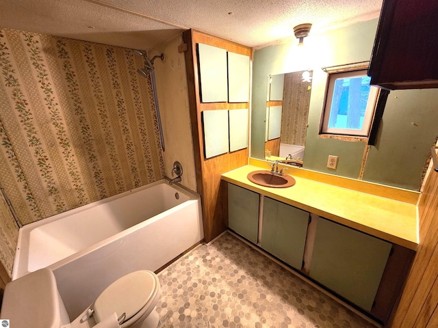 full bathroom with vanity, a textured ceiling, shower / bath combination, and toilet