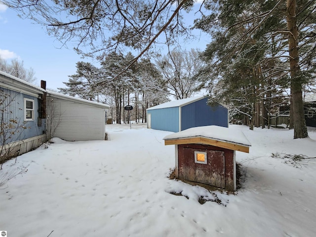 snowy yard featuring an outdoor structure