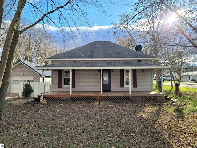 view of front facade featuring an outbuilding, a porch, and a garage