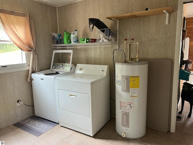 laundry area with electric water heater, washer and clothes dryer, and light tile patterned floors