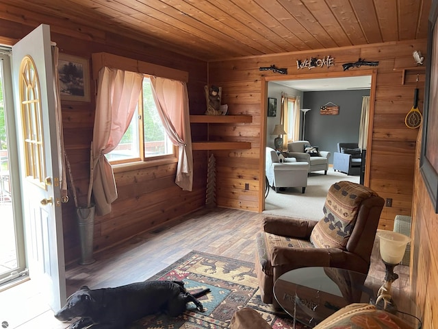 sitting room featuring wood-type flooring, wooden walls, and wood ceiling