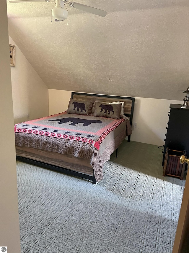 bedroom featuring ceiling fan, lofted ceiling, and a textured ceiling