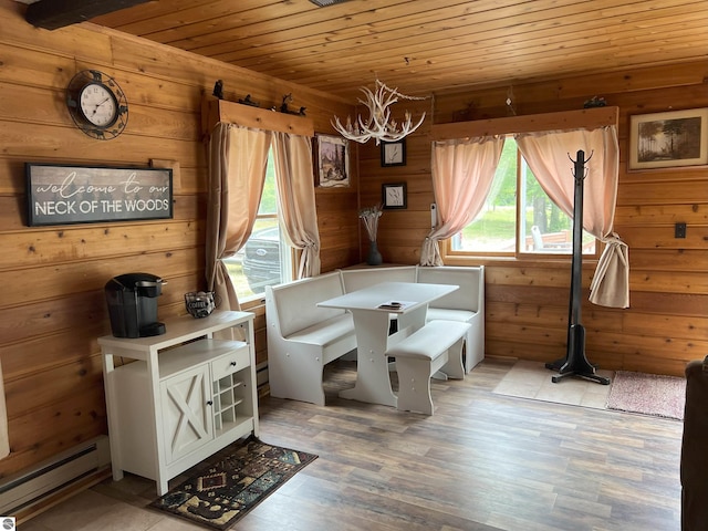 dining area with wooden ceiling, wood walls, wood-type flooring, and a baseboard radiator