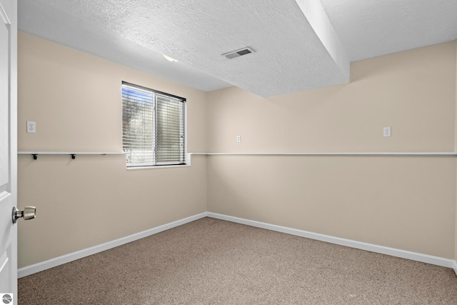 empty room featuring carpet flooring and a textured ceiling