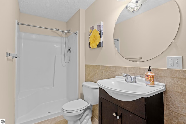 bathroom featuring a textured ceiling, toilet, tile walls, and walk in shower