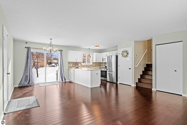 kitchen with hanging light fixtures, dark wood-type flooring, a notable chandelier, white cabinets, and appliances with stainless steel finishes