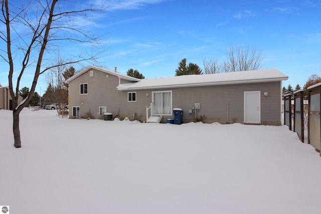 snow covered house featuring cooling unit