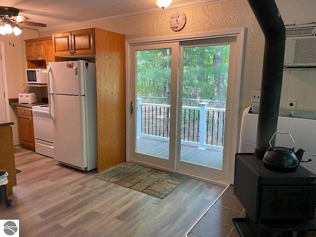 doorway to outside with a wood stove, light hardwood / wood-style flooring, ceiling fan, and an AC wall unit