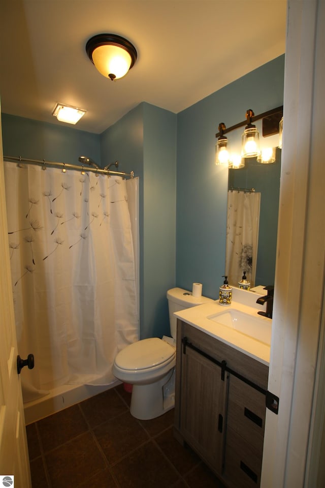 bathroom with tile patterned floors, vanity, curtained shower, and toilet