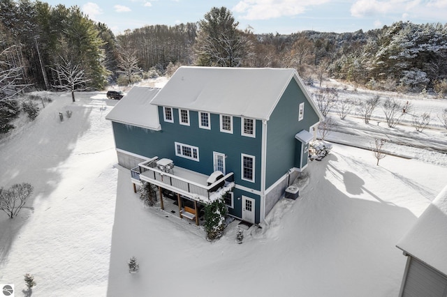 snow covered house featuring a deck