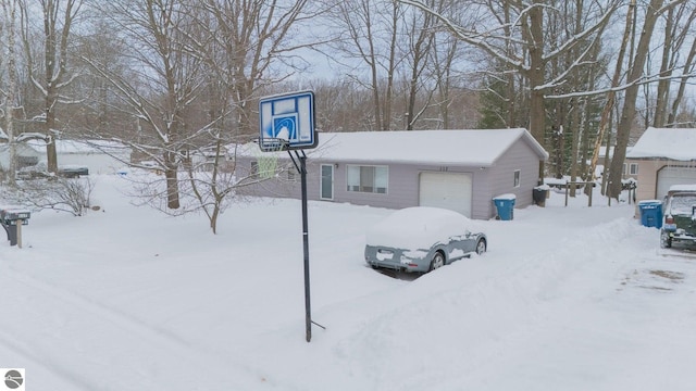 snow covered structure with a garage