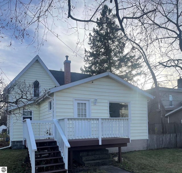 rear view of property with stairway, a chimney, roof with shingles, and a deck