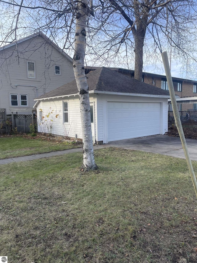 traditional-style house featuring an attached garage, a shingled roof, a front yard, and fence