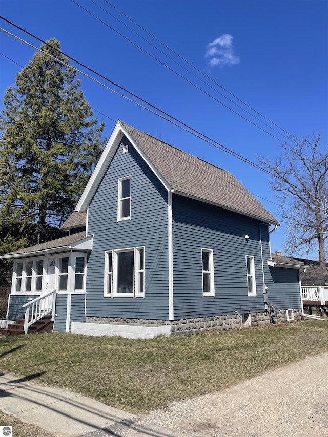309 E Wisconsin, Mount Pleasant, MI 48858 - view of side of property with roof with shingles, a lawn, and entry steps