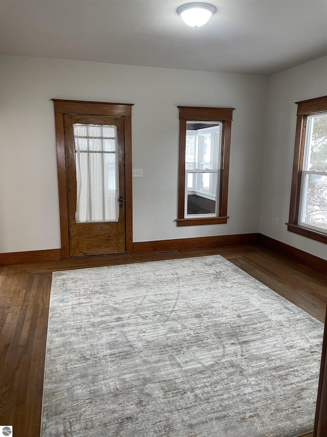 spare room featuring baseboards and wood finished floors