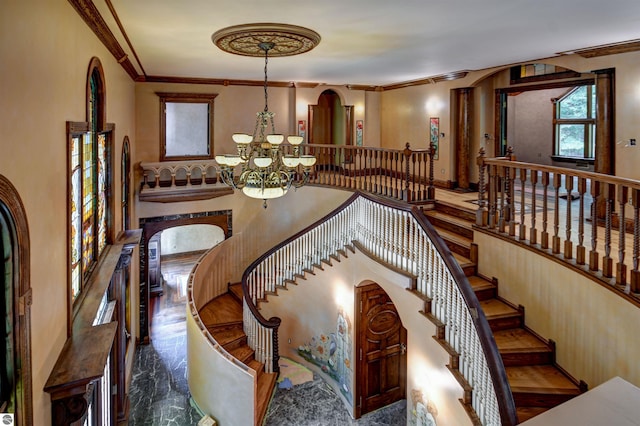 staircase featuring ornamental molding and a notable chandelier