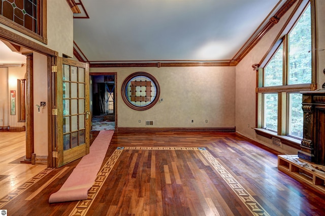 unfurnished living room featuring hardwood / wood-style floors, high vaulted ceiling, and a healthy amount of sunlight