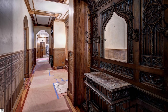 hallway with ornamental molding and light carpet