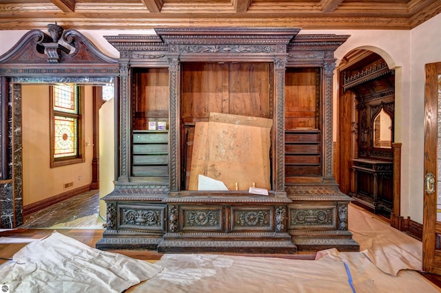 interior details featuring beamed ceiling, coffered ceiling, and ornamental molding