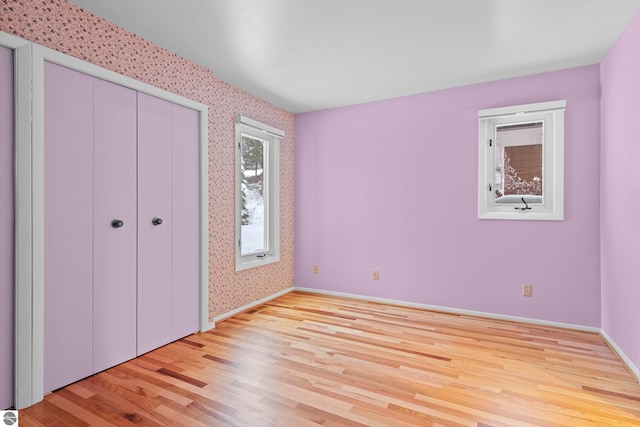 unfurnished bedroom with a closet and light hardwood / wood-style flooring