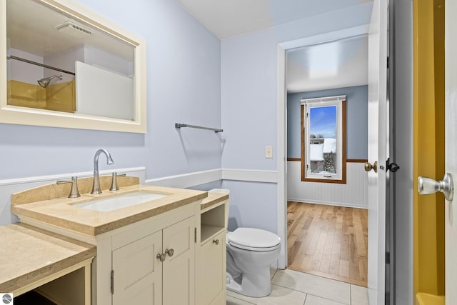 bathroom with hardwood / wood-style floors, vanity, and toilet