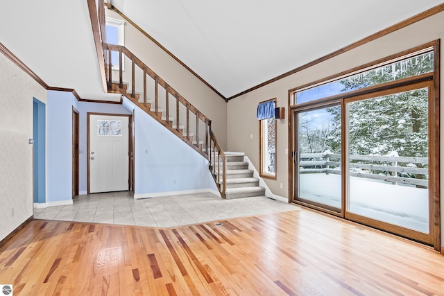 entrance foyer featuring crown molding, high vaulted ceiling, and light hardwood / wood-style floors