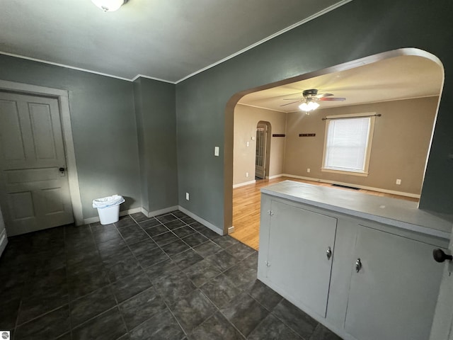 interior space with ceiling fan and ornamental molding