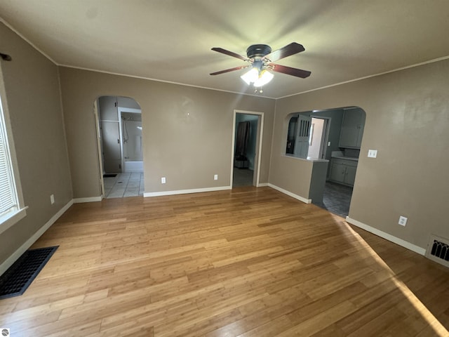 unfurnished room featuring light wood-type flooring, ceiling fan, and ornamental molding