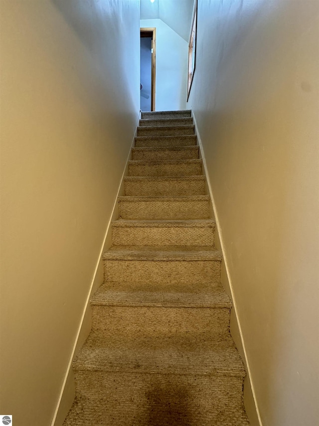 stairs featuring carpet flooring and lofted ceiling