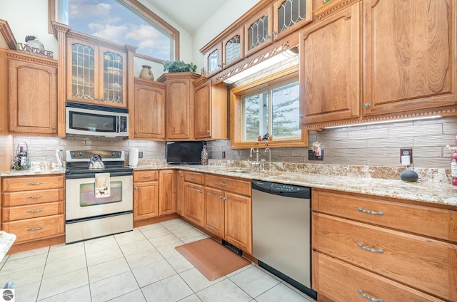 kitchen featuring plenty of natural light, stainless steel appliances, vaulted ceiling, and sink