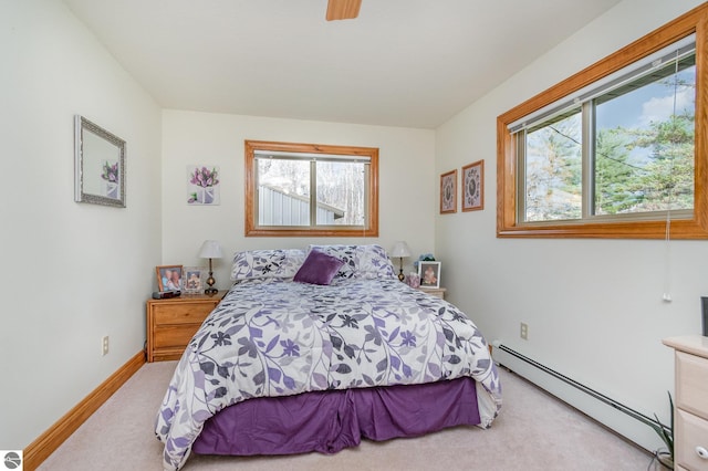 bedroom featuring multiple windows, light carpet, and baseboard heating