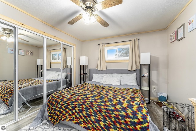 bedroom featuring hardwood / wood-style flooring, ceiling fan, crown molding, and a closet