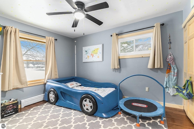 bedroom with hardwood / wood-style flooring, ceiling fan, and baseboard heating