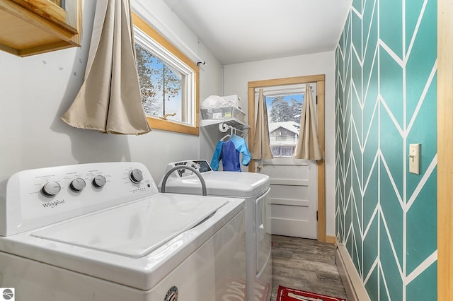 laundry room with hardwood / wood-style floors, washer and clothes dryer, and cabinets