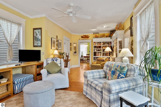 living room featuring ceiling fan, baseboards, wood finished floors, and ornamental molding