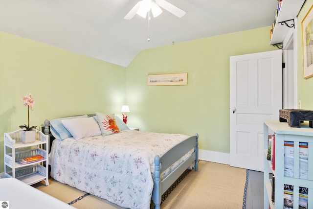 bedroom featuring lofted ceiling, a ceiling fan, and baseboards