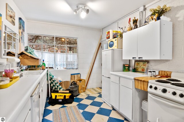 kitchen featuring light floors, light countertops, white cabinets, and white appliances