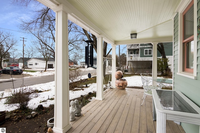 snow covered deck featuring a porch